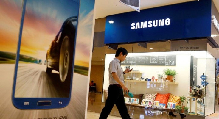 A man using his mobile phone walks past a Samsung Electronics shop in the company's main office building in central Seoul July 23, 2013. Samsung Electronics Co Ltd is under mounting pressure to produce eye-catching new smartphones after its mobile business shrank 3.5 percent in the second quarter, taking the gloss off a record $8.5 billion operating profit. Picture taken July 23.     REUTERS/Lee Jae-Won (SOUTH KOREA - Tags: BUSINESS LOGO)